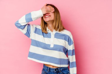 Pembe arka planda soyutlanmış beyaz bir kadın ellerini başının üstünde tutarak neşe içinde gülüyor. Mutluluk kavramı.