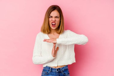 Pembe arka planda izole edilmiş genç beyaz kadın bir mola hareketi gösteriyor..