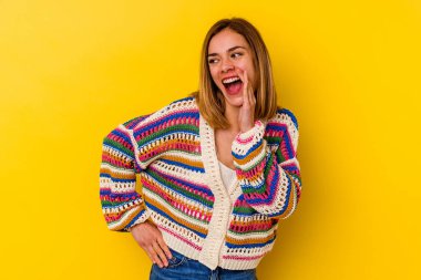 Sarı arka planda izole edilmiş beyaz tenli genç bir kadın heyecanlı bir şekilde bağırıyor..