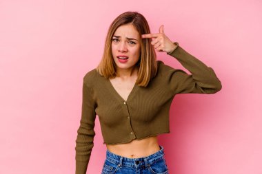 Pembe arka planda izole edilmiş beyaz bir kadın işaret parmağıyla hayal kırıklığı jesti gösteriyor..