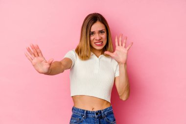 Pembe arka planda izole edilmiş beyaz bir kadın. İğrenme belirtisi gösteren birini reddediyor..