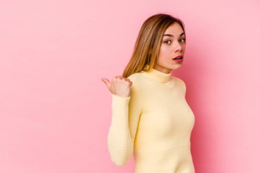 Pembe arka plan noktalarında izole edilmiş genç beyaz kadın başparmak uzakta, gülüyor ve kaygısız..