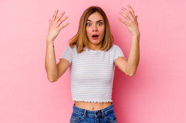 Pembe arka planda izole edilmiş genç beyaz kadın on numarayı elleriyle gösteriyor..