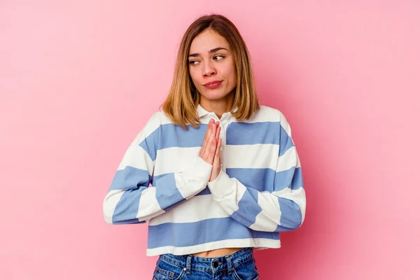 Pembe Arka Planda Izole Edilmiş Genç Beyaz Kadın Dua Ediyor — Stok fotoğraf
