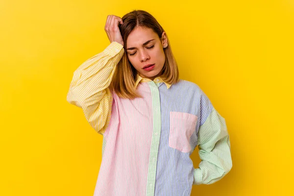 Young caucasian skinny woman isolated on yellow background tired and very sleepy keeping hand on head.