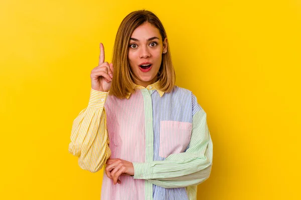 Young caucasian skinny woman isolated on yellow background having some great idea, concept of creativity.