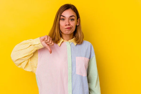 Young caucasian skinny woman isolated on yellow background showing thumb down, disappointment concept.