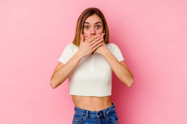 Pembe arka planda izole edilmiş beyaz bir kadın elleriyle ağzını kapatırken şok oldu..