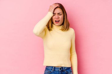 Pembe arka planda soyutlanmış beyaz bir kadın bir şeyi unutuyor. Alnına avuç içi ve gözlerini kapatıyor..