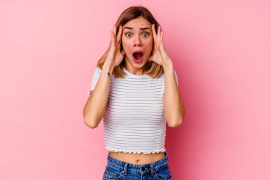 Pembe arka planda izole edilmiş beyaz bir kadın yüzünün yarısını palmiye ile örterek eğleniyor..