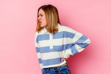 Pembe arka planda izole edilmiş beyaz bir kadın sırt ağrısı çekiyor..