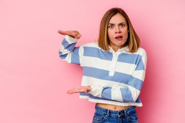 Pembe arka planda izole edilmiş genç beyaz kadın elleri arasında bir kopya alanı tutarken şok ve hayrete düştü..