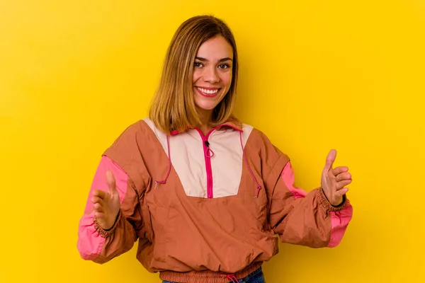 若いですCaucasianスキニー女性隔離上の黄色の背景保持何かで両手 製品プレゼンテーション — ストック写真