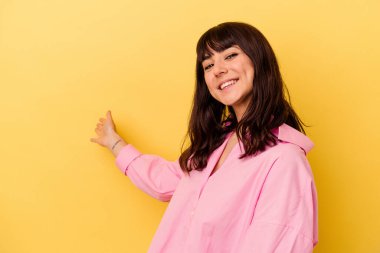 Sarı arka planda izole edilmiş beyaz bir kadın hoş bir yüz ifadesi sergiliyor..