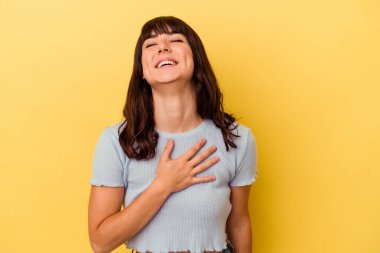 Sarı arka planda yalnız yaşayan beyaz bir kadın elini göğsüne koyduğunda kahkahalar atıyor..