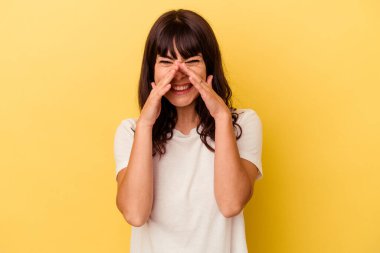 Sarı arka planda izole edilmiş genç beyaz kadın bir dedikodu söylüyor, bir şeyi haber veriyor..