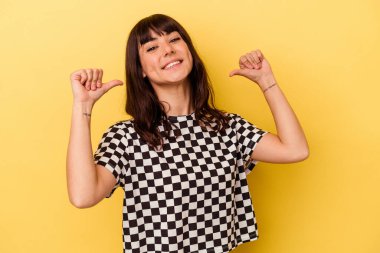 Sarı arka planda izole genç beyaz kadın gururlu ve kendinden emin hissediyor, örnek olarak..