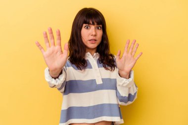 Sarı arka planda izole genç beyaz kadın yakın bir tehlike nedeniyle şoka uğruyor.