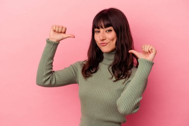 Pembe arka planda izole genç beyaz kadın gururlu ve kendinden emin hissediyor, örnek olarak..