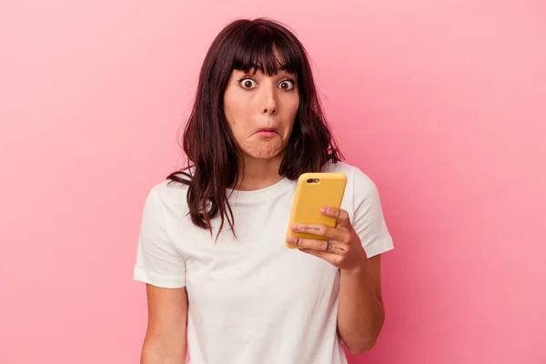 Young Caucasian Woman Holding Mobile Phone Isolated Pink Background Shrugs — Stock Photo, Image