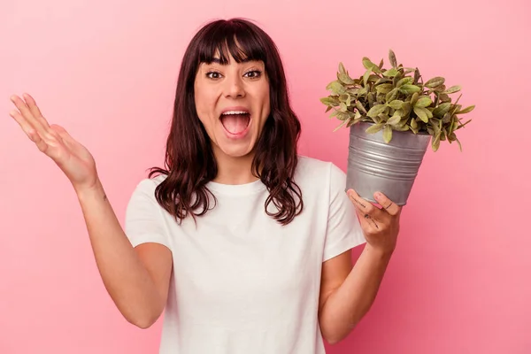 Jonge Kaukasische Vrouw Houden Van Een Plant Geïsoleerd Roze Achtergrond — Stockfoto