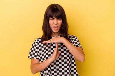 Sarı arka planda izole edilmiş genç beyaz kadın bir mola hareketi gösteriyor..