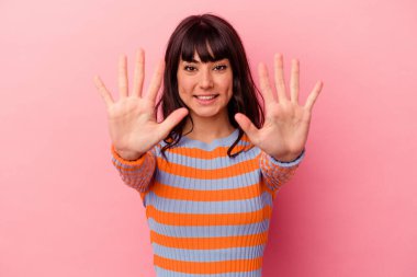 Pembe arka planda izole edilmiş genç beyaz kadın on numarayı elleriyle gösteriyor..