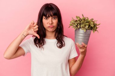 Pembe arka planda saklanmış bir bitkiyi tutan beyaz bir kadın, hoş olmayan bir jest gösteriyor, kabul etmiyor. Anlaşmazlık konsepti.