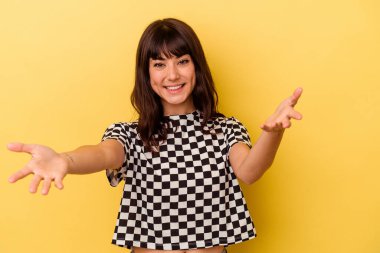 Sarı arka planda izole edilmiş beyaz bir kadın hoş bir yüz ifadesi sergiliyor..