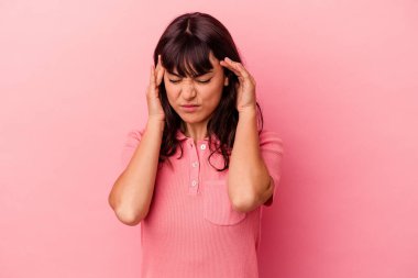 Genç beyaz kadın pembe arka planda izole edilmiş tapınaklara dokunuyor ve baş ağrısı çekiyor..