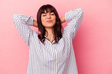 Genç, beyaz bir kadın pembe arka planda izole edilmiş. Durağan yaşam tarzından dolayı boyun ağrısı çekiyor..