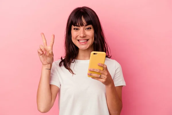 Joven Mujer Caucásica Sosteniendo Teléfono Móvil Aislado Sobre Fondo Rosa —  Fotos de Stock