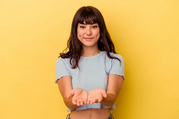 Mujer Joven Caucásica Aislada Sobre Fondo Amarillo Sosteniendo Algo Con —  Fotos de Stock