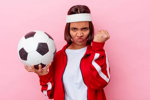 若い混合人種の女性は カメラに拳を示すピンクの背景に隔離されたサッカーをプレイ 積極的な顔の表情 — ストック写真