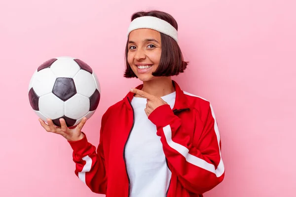 Jovem Mestiça Jogando Futebol Isolado Fundo Rosa Sorrindo Apontando Para — Fotografia de Stock