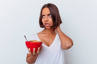 Beyaz arka planda izole edilmiş mısır gevreği yiyen, düşünen ve bir seçim yapan genç bir ırk kadını..