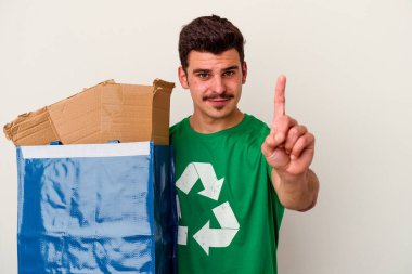 Beyaz arka planda izole edilmiş karton geri dönüşümü yapan beyaz bir adam.
