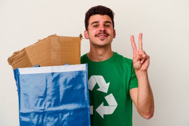 Beyaz arka planda izole edilmiş karton geri dönüşümü yapan beyaz bir adam.