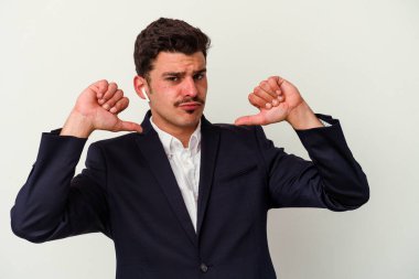 Beyaz arka planda izole edilmiş kablosuz kulaklık takan genç beyaz iş adamı gururlu ve kendinden emin hissediyor, örnek olarak.