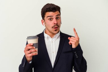 Kablosuz kulaklık takan ve elinde tuttuğu beyaz arka planda izole edilmiş kahve alan beyaz iş adamı harika bir fikir, yaratıcılık kavramı.