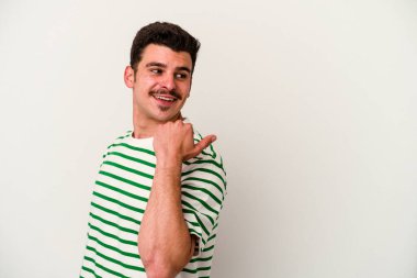 Beyaz arka planda izole genç beyaz adam parmak uzakta, gülüyor ve kaygısız.