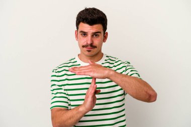 Beyaz arka planda izole edilmiş genç beyaz bir adam bir mola hareketi gösteriyor..
