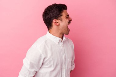 Pembe arka planda izole edilmiş genç beyaz adam fotokopi odasına doğru bağırıyor.