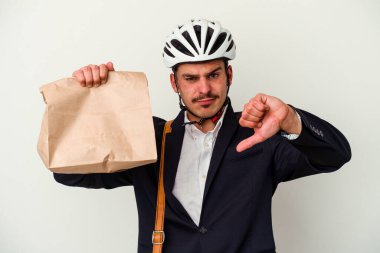 Bisiklet kaskı takan ve elinde tuttuğu genç beyaz arka planda izole edilmiş yiyecekleri saklayan beyaz bir adam hoş olmayan bir jest yapıyor. Anlaşmazlık konsepti.