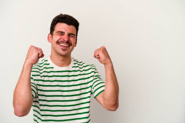 Beyaz arka planda izole edilmiş genç beyaz bir adam zaferden sonra yumruğunu kaldırıyor, kazanan konsept.