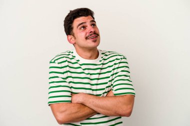 Beyaz arka planda izole edilmiş genç beyaz adam hedeflere ve amaçlara ulaşmayı hayal ediyor.