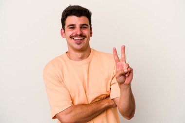 Beyaz arka planda izole edilmiş genç beyaz adam iki numarayı parmaklarıyla gösteriyor..