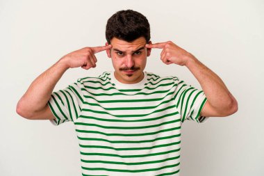 Beyaz arka planda izole edilmiş genç beyaz bir adam bir göreve odaklanmış, işaret parmaklarını işaret ediyor..