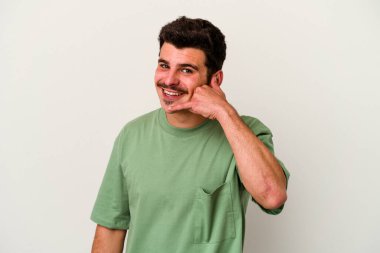 Beyaz arka planda izole edilmiş genç beyaz bir adam parmakları olan bir cep telefonu hareketi gösteriyor..