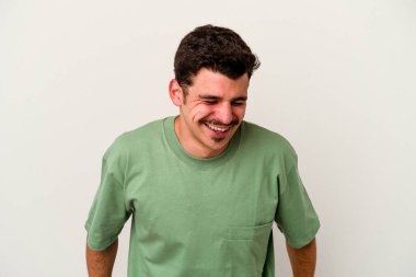 Beyaz arka planda izole edilmiş genç beyaz adam gülüyor ve gözlerini kapıyor, rahatlamış ve mutlu hissediyor..